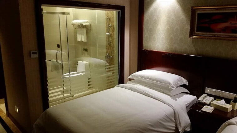A Bed Right Next to the Bathroom