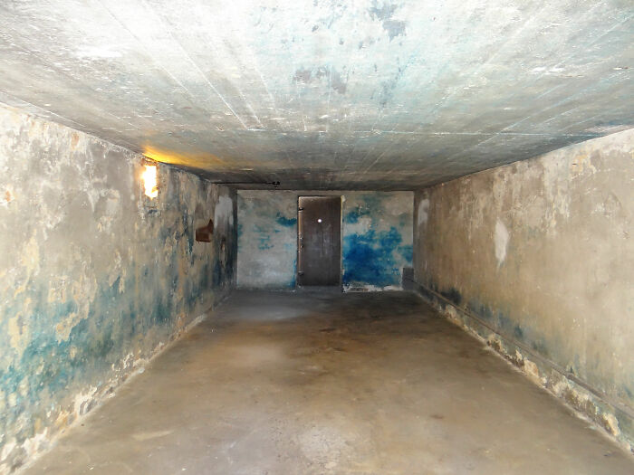 Empty medieval dungeon room with worn walls and dim lighting, representing t*****e methods and devices in history.